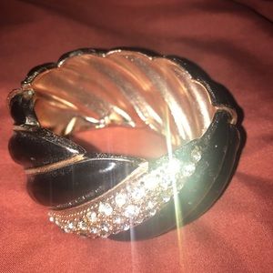 black bracelet.encrusted with imitation diamonds. opens to allow the hand in.